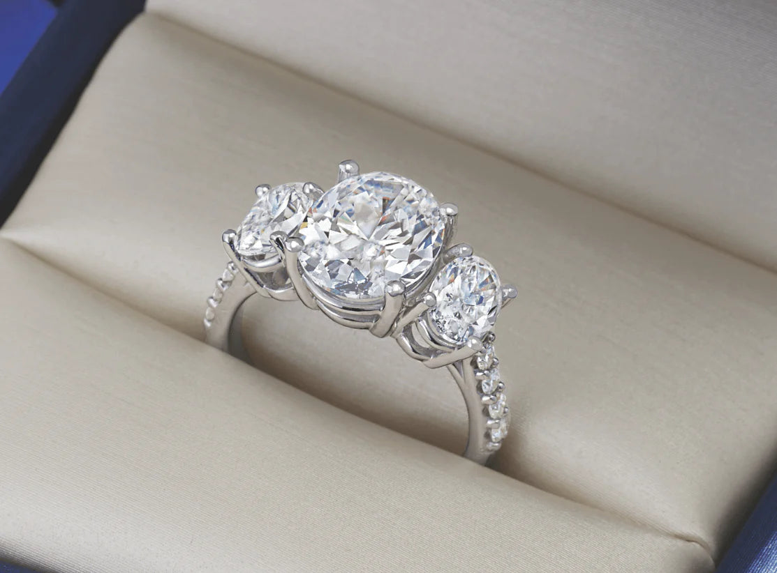 Bespoke three-stone engagement ring featuring mixed diamond cuts and sapphire gemstones to symbolize a unique journey.