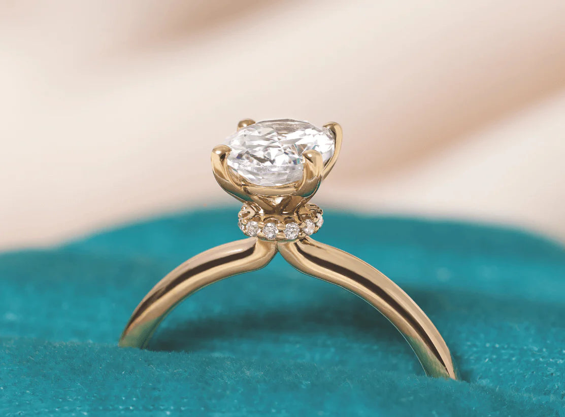 Made-to-order hidden halo engagement ring with a discreet circle of diamonds visible from the side profile.